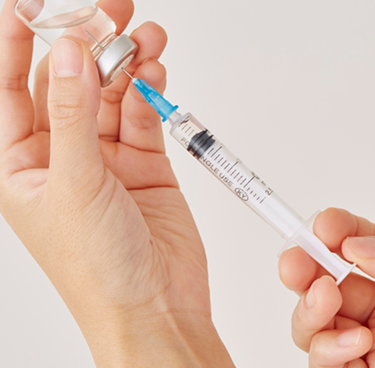 a close-up of a syringe and a vial