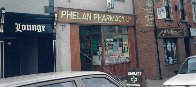 a pharmacy store front with cars parked in front of it