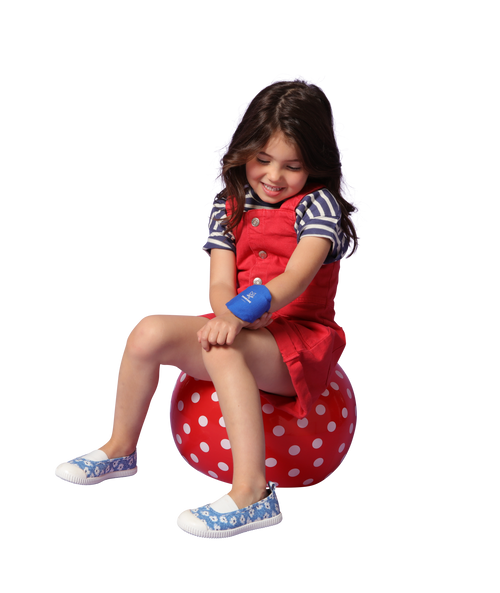 a girl sitting on a red polka dot ball